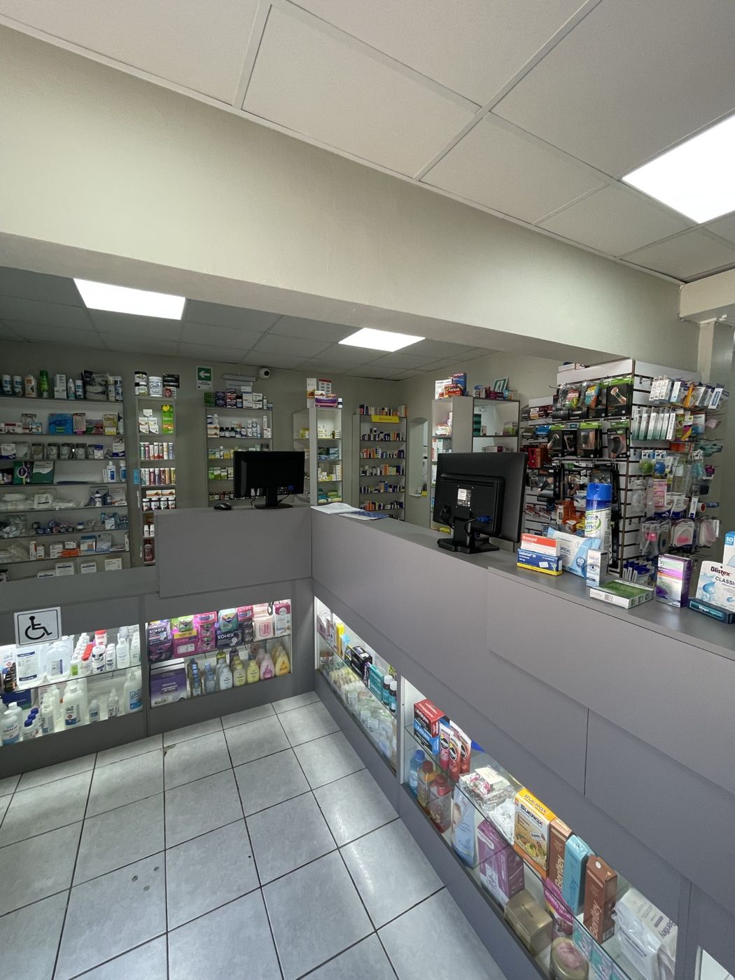 Interior de la farmacia con estanterías y mesón