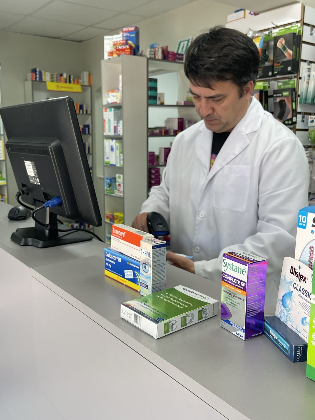 Químico farmacéutico atendiendo en el mesón